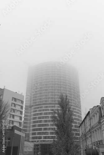 Fog covers the top of the building. Fog over residential buildings