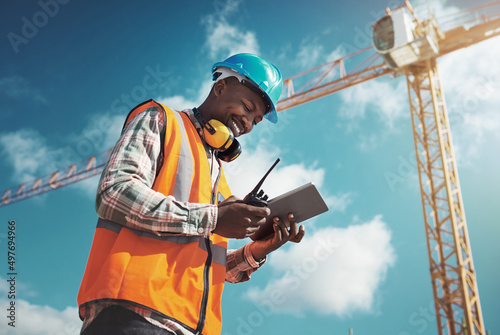 New age tech for new age construction. Shot of a young man using a digital tablet while working at a construction site.