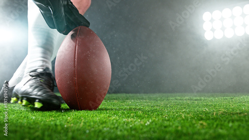 Fotografía American football player kicking ball on grass.