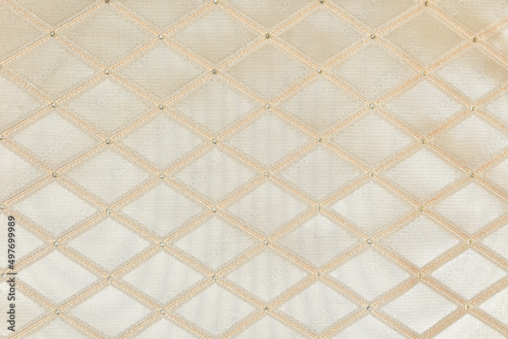 Rhombus pattern on a beige background. Polyester fabric, jacquard close-up Rhombus pattern on a beige background. Polyester fabric, jacquard close-up
