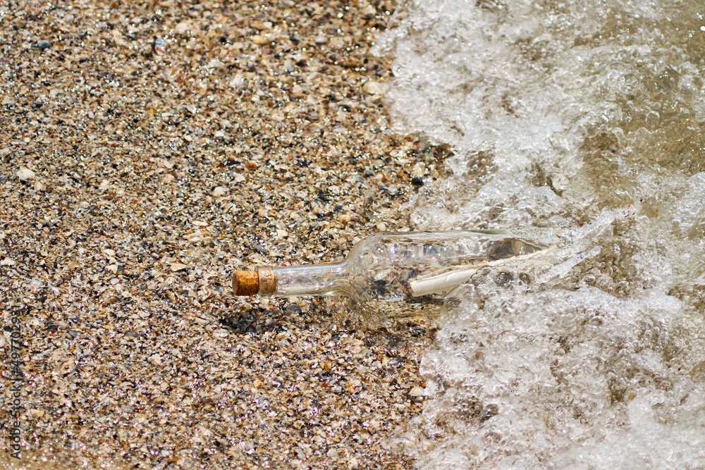 A bottle with a letter thrown out of the sea on a sandy shore. A bottle with a letter thrown out of the sea on a sandy shore.