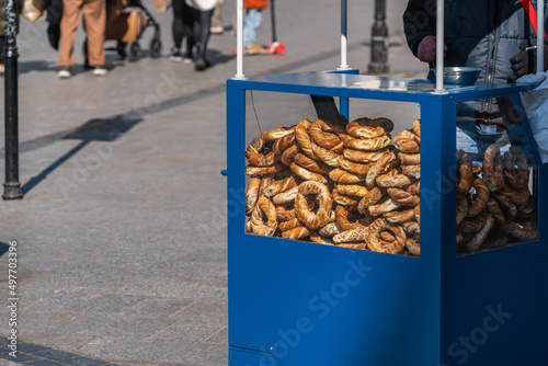 Polish street food - Polish bagels in Krakow, round pretzels with poppy seeds and cumin behind the glass of a street stall in the sunlight photo