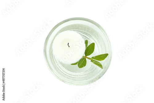 Glass of water with candle and twig isolated on white background
