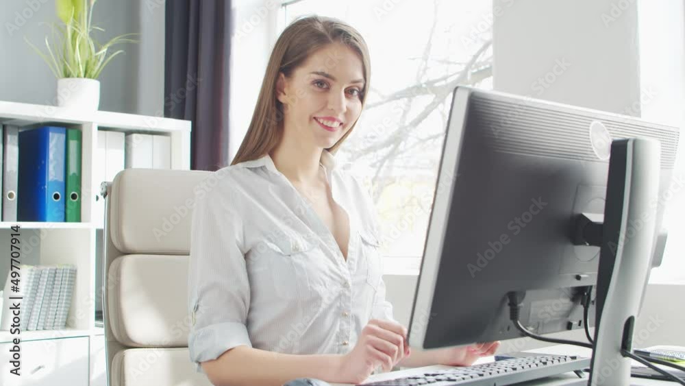 Young Woman Works at Office Using Computer. Workplace of Entrepreneur, Manager or Businesswoman. Remote Work and Education Concept. Young Woman Works at Office Using Computer. Workplace of Entrepreneur, Manager or Businesswoman. Remote Work and Education Concept.