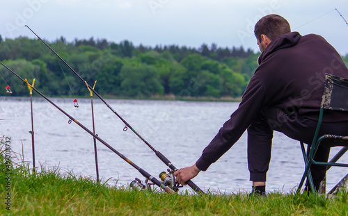 Close-up of a fishing rod wheel, a man is fishing. Nature