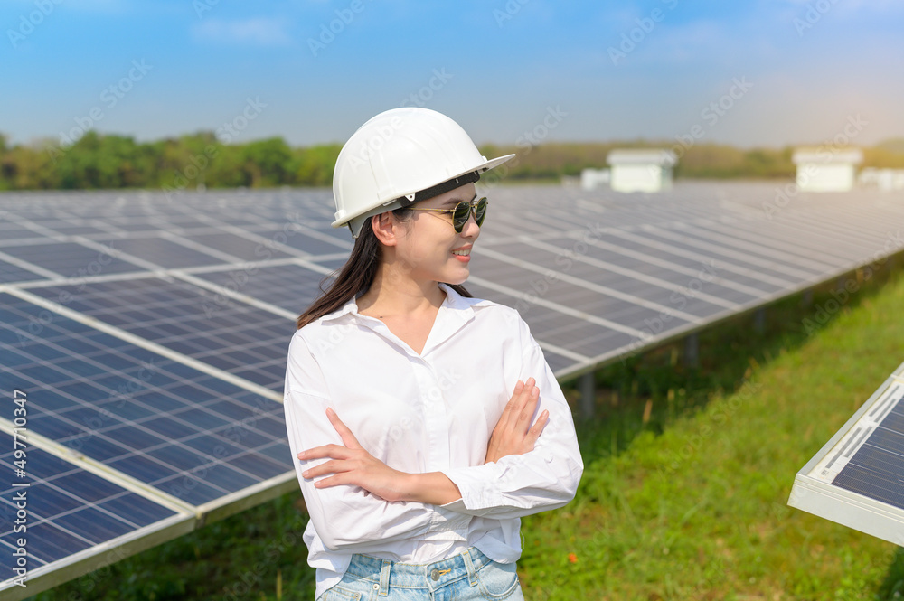 Female engineer wearing helmet in Photovoltaic Cell Farm or Solar Panels Field, eco friendly and clean energy. Female engineer wearing helmet in Photovoltaic Cell Farm or Solar Panels Field, eco friendly and clean energy.
