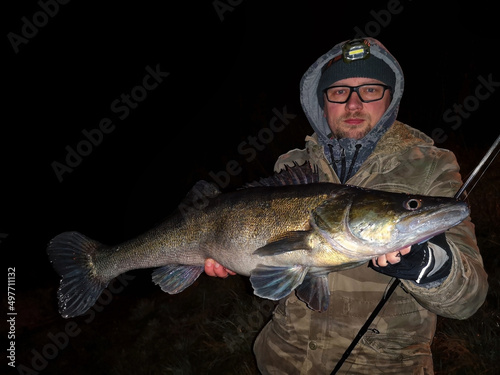 Angler mit gefangenem Zander beim Nachtangeln