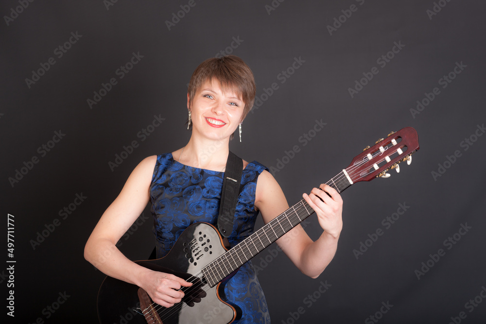 Fototapeta premium woman with a guitar on a black background