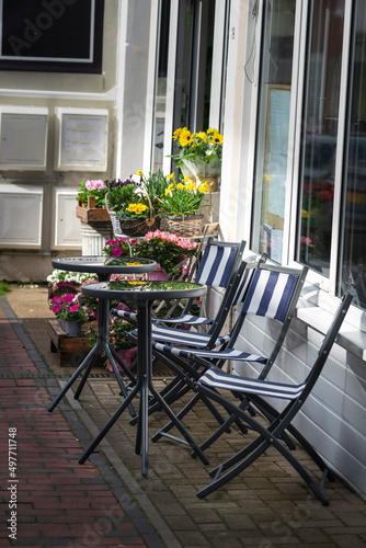 Outside seating of a streetside cafe with flowers