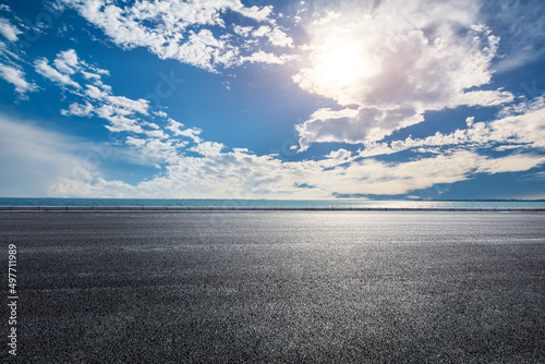 Empty asphalt road and sky clouds with lake background at sunset © ABCDstock