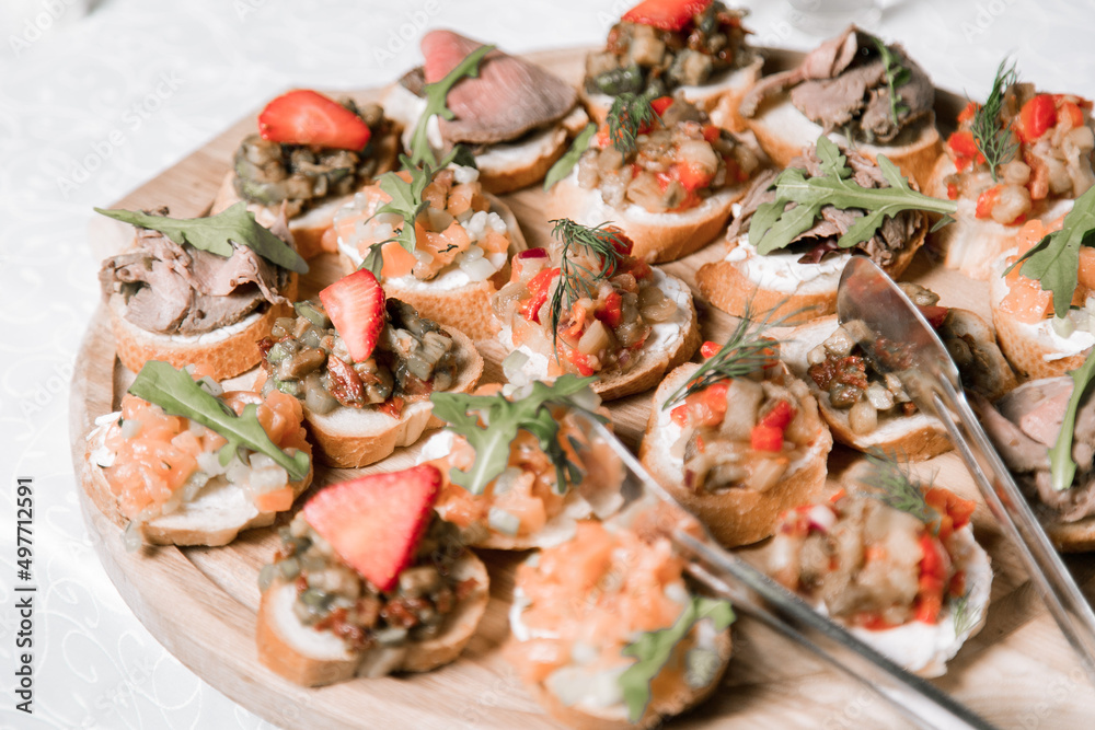 Decorated catering banquet table with different food appetizers assortment on a party Decorated catering banquet table with different food appetizers assortment on a party
