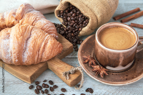 Cup of coffee and croissants on the table. Fragrant stimulating drink. Fresh bakery. Breakfast, snack.