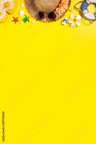 Summer beach design concept with shells, hat, slipper on yellow background.