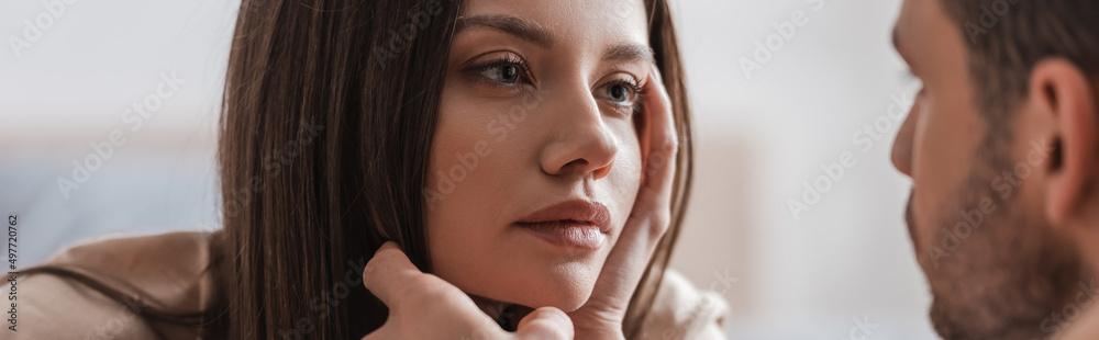 Blurred man touching face of young girlfriend at home, banner.