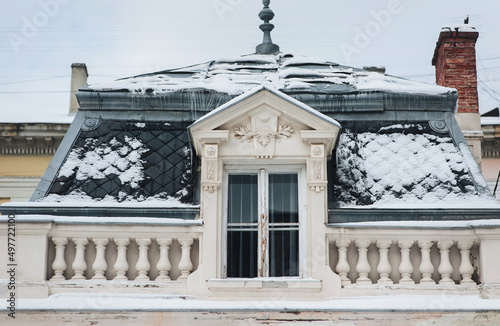 Roof with attic and snow-covered tiled roof and white balustrade. Potocki Palace in Lviv, Ukraine. photo