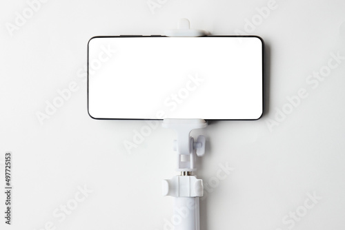 Selfie stick with smart phone on white background