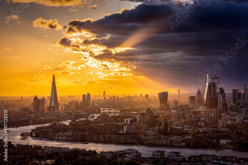 Panorama of the London skyline during a cloudy sunset with soft sunlight and couds over the city