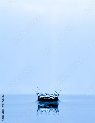 Splash and crown on white background. Reflection on the surface of the water.