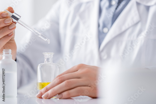 cropped view of laboratory assistant holding serum with pipette. © LIGHTFIELD STUDIOS