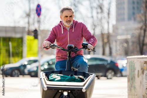 Mature man riding a cargo bike in the city
