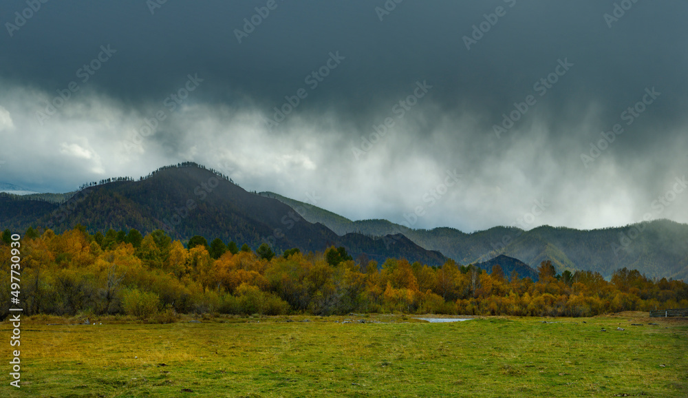 Russia. South of Western Siberia, the Altai Mountains. The first snow storm in the valley of the Karakol River is coming for a warm autumn.