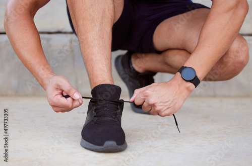 Put on your shoes and go for a run. Cropped shot of an unrecognizable man tying his shoelaces.