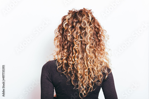 Back view of naturally curly hair young woman photo