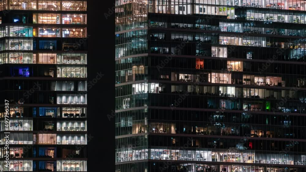 Time-lapse blinking office windows lights in business center building facade, people working late night. Corporate business, high skyscraper glass surface. Light in building windows turn on and off Time-lapse blinking office windows lights in business center building facade, people working late night. Corporate business, high skyscraper glass surface. Light in building windows turn on and off