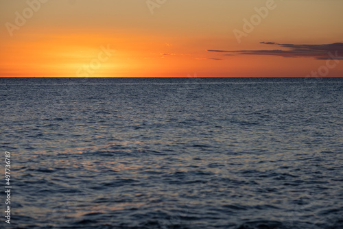 Sunset on the Caribbean coast in the Dominican Republic.Orange sunset sky with a cloud and a calm sea surface.Tourism  travel  recreation  concepts background.Beautiful scenery of the sea coast