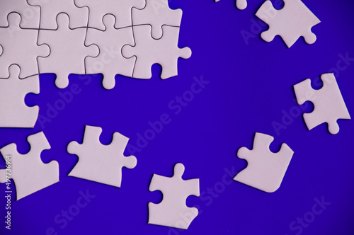Top view of missing jigsaw puzzle on blue cover background. Copy space.
