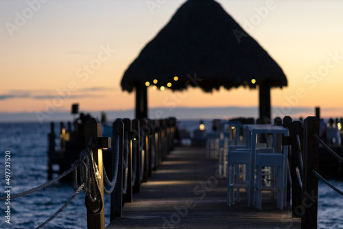 Sunset on the Caribbean coast in the Dominican Republic.Restaurant on the pier in the evening.An open-air cafe with a view of the sunset and the Caribbean Sea. Silhouettes against the dark sunset sky