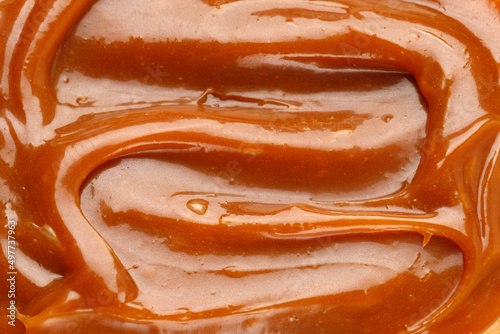 Liquid caramel syrup. Background of caramel paste. Texture Close up, top view.