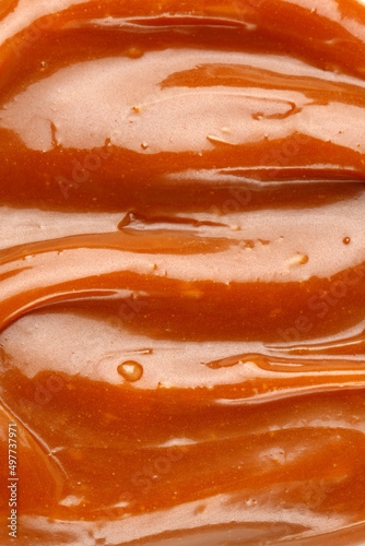 Liquid caramel syrup. Background of caramel paste. Texture Close up, top view.