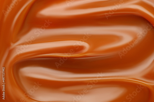 Liquid caramel syrup. Background of caramel paste. Texture Close up, top view. photo
