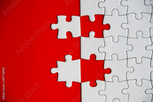 Top view of missing jigsaw puzzle on red cover background. Copy space