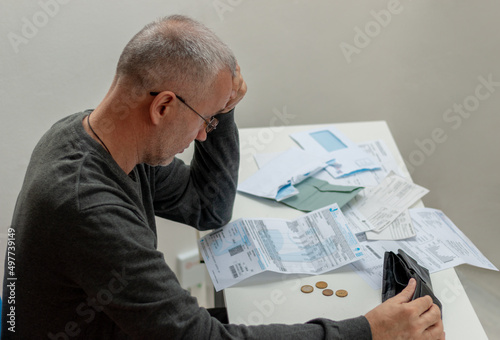 Mature man sitting at home, stressed and confused by calculate expense from invoice or bill, have no money to pay, mortgage or loan. Debt, bankruptcy or bankrupt concept