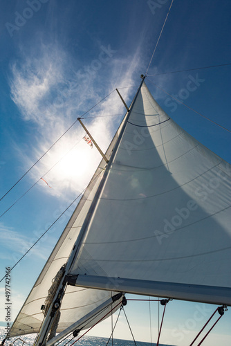 Dettaglio di vele su sfondo cielo azzurro durante una regata in mare