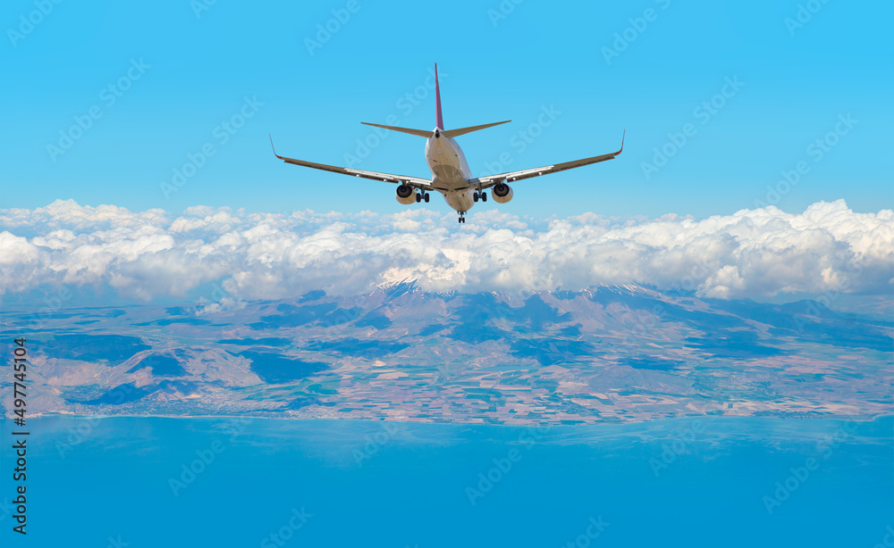 Fototapeta premium Airplane landing to airport runway Blue sea and dense clouds in the background