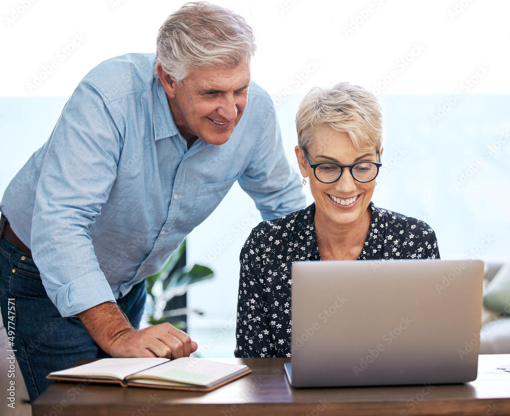 This looks really good. Shot of a mature couple using a laptop at home. This looks really good. Shot of a mature couple using a laptop at home.