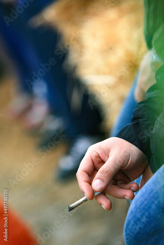 Dettaglio di un amano di un uomo che fuma uno spinello in contesto esterno photo