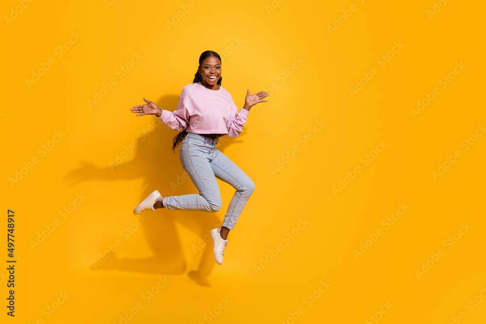 Full length photo of overjoyed cheerful girl raise arms palms isolated on yellow color background