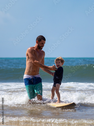 PAI ENSINANDO FILHO A SURFAR.