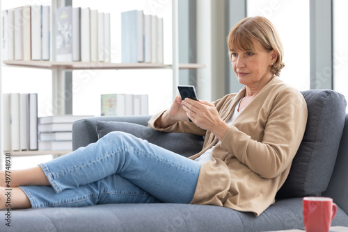 senior woman using smartphone for work in free time