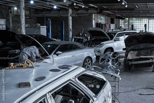 Car service worker repairs restores car