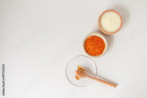 Natural ingredients for homemade face mask, top view of yoghurt, turmeric  and honey on white background, beauty skincare product concept, flat lay