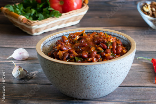 Georgian lobio made of stewed red beans in a bowl on a wooden background