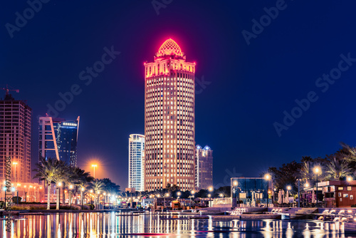 Iconic Ooredoo Tower in West bay Doha City at night with numeros lights