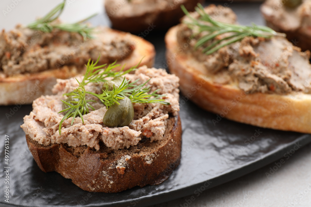 Slices of bread with delicious pate on light grey table, closeup