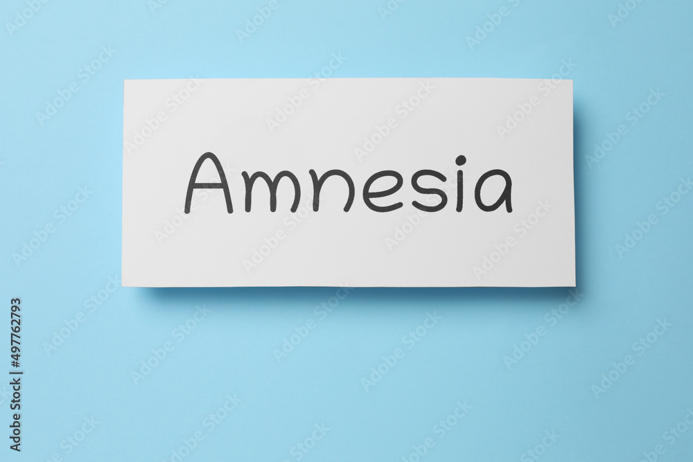 Fototapeta premium Card with word Amnesia on light blue background, top view
