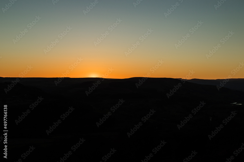 Sunset sky with silhouetted hills